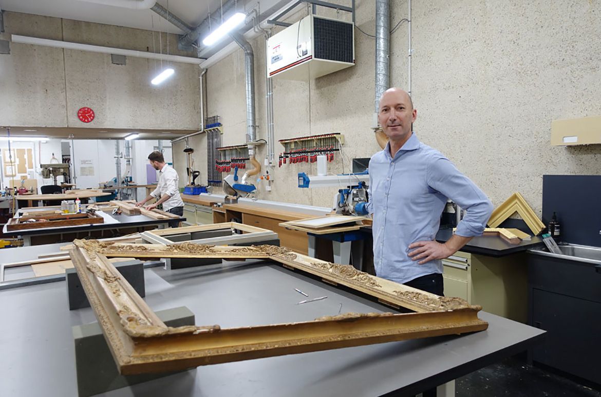 The view into the restoration and assembly room / Photography: Raf NathanRobert Zilli
stands before a valuable frame that will be painstakingly restored.