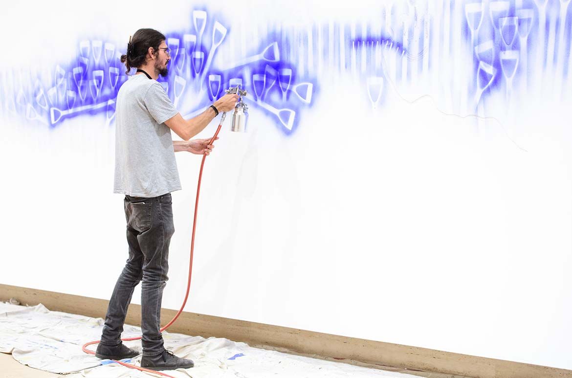 D Harding working on their commission Wall Composition in Reckitt’s Blue / Photograph: C Callistemon © QAGOMA
