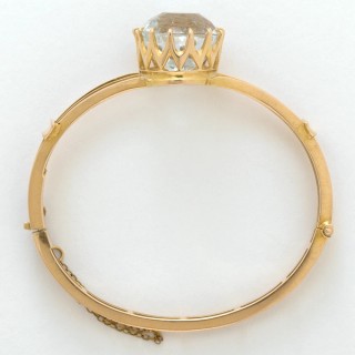 Mackay and Co. Australia active 1884–1982 / Gold and topaz bangle c.1900 / 18k yellow gold in hinged triple-bar design, set with a large central facetted topaz, approx. 22.5cts / 5.5cm (inside diam.); 24 grams (weight) / Purchased 2020. Queensland Art Gallery | Gallery of Modern Art Foundation / Collection: Queensland Art Gallery | Gallery of Modern Art