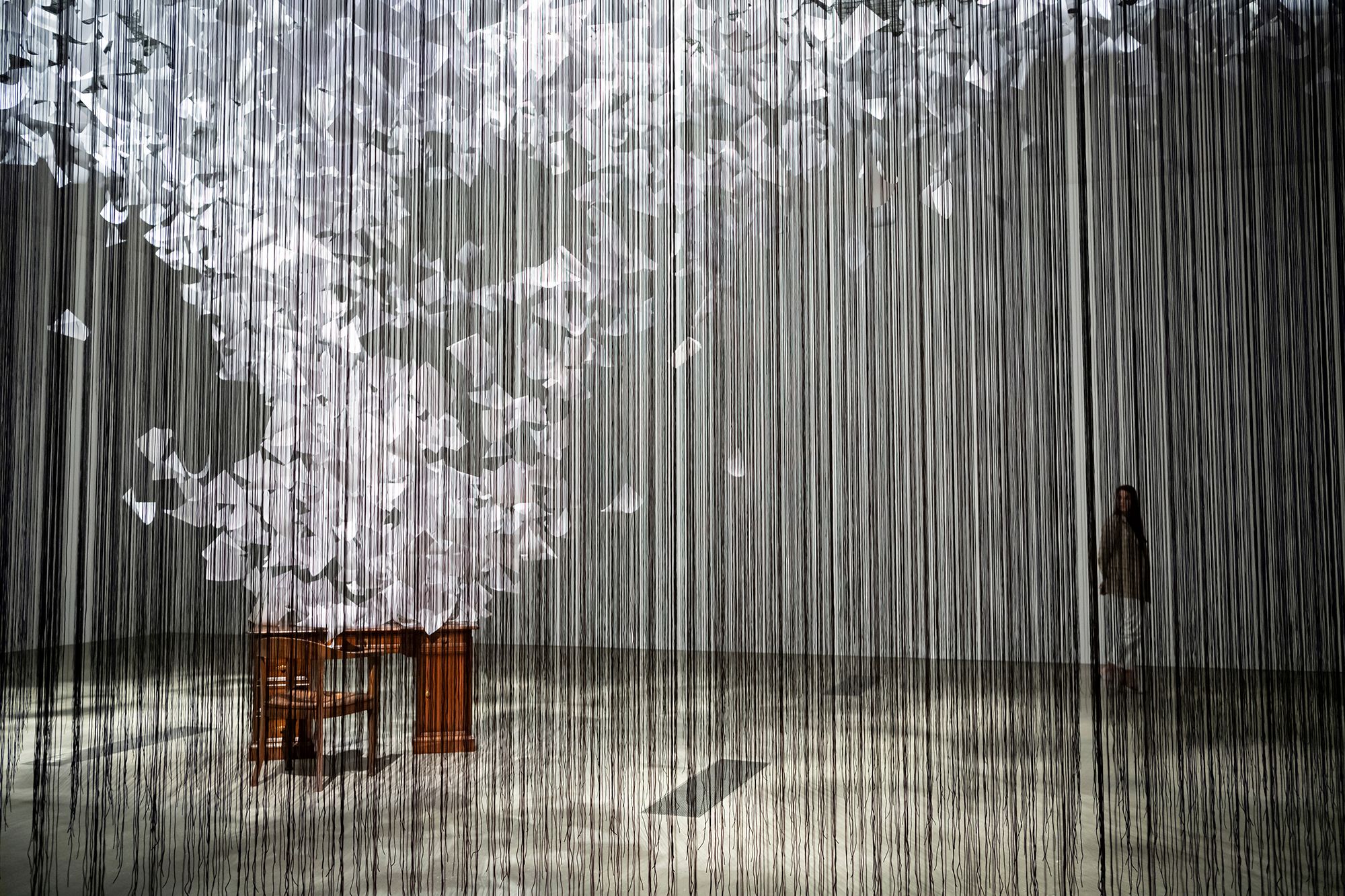 Chiharu Shiota, Japan/Germany b.1972 / A question of perspective 2022 in ‘The Soul Trembles’, Gallery of Modern Art, Brisbane / Polypropylene ropes, 80mg paper, found furniture, cable ties, staples / 500 x 810 x 1215cm / Commissioned 2022 with funds from Tim Fairfax AC through the QAGOMA Foundation / Collection: Queensland Art Gallery | Gallery of Modern Art / © Chiharu Shiota / Photograph: C Callistemon © QAGOMA