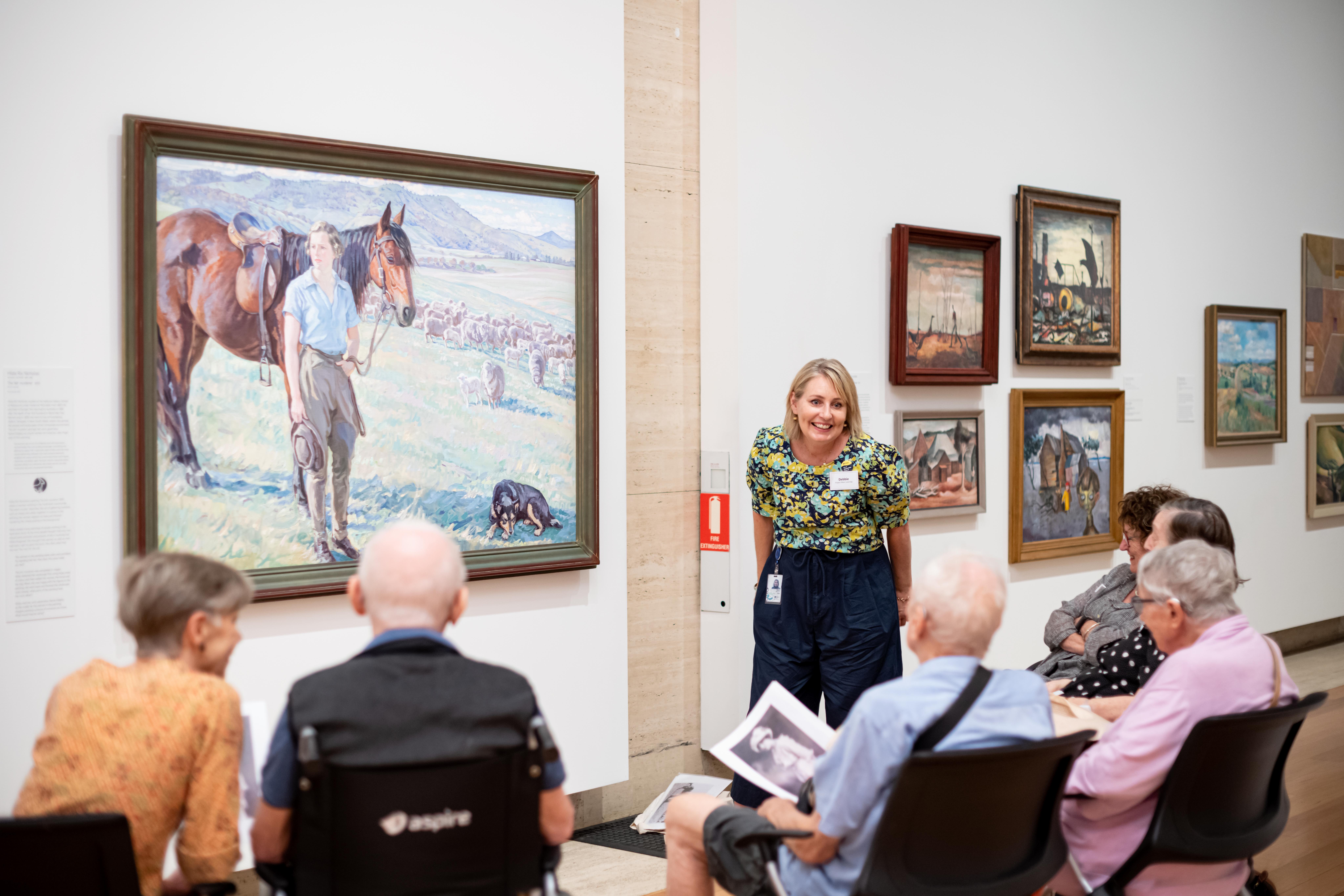 Art and Dementia program participants engage in guided slow-viewing of Hilda Rix Nicholas, Australia 1884–1961 / The fair musterer 1935 / Oil on canvas / 102.3 x 160.4cm / Purchased 1971 / Collection: Queensland Art Gallery | Gallery of Modern Art / © QAGOMA / Photograph: C Callistemon