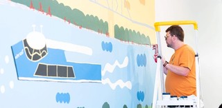 Artist & Autism Queensland ambassador Martin Edge installing his mural in the QAG Cafe, 2020 / Photograph: C Callistemon © QAGOMA