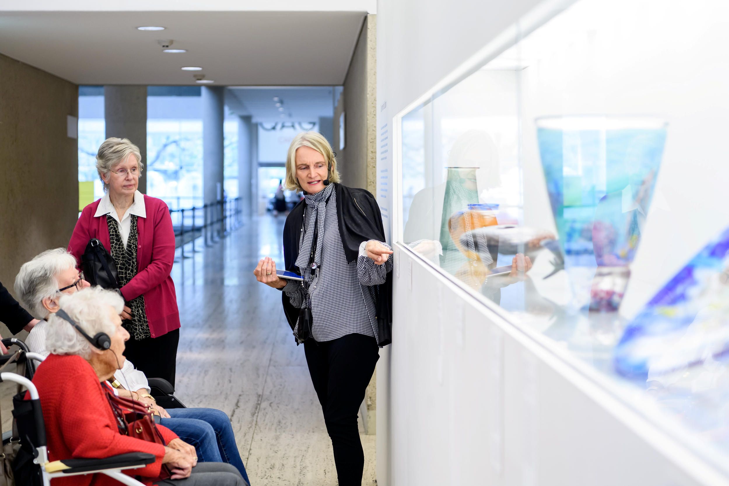 Visitors with hearing loss use assistive listening devices during a volunteer guided tour at the Queensland Art Gallery. Photograph: C. Callistemon