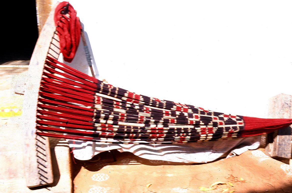 Weft is wound onto the frame with 15 dyed bundles to create this design, Puttapaka, 1999 / Photograph: Dana McCown