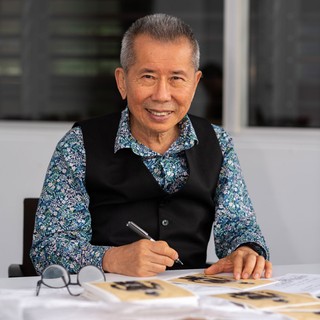 William Yang signing prints of his work Golden Summer 1987/2016 to accompany a special limited edition of the exhibition publication, GOMA, December 2020 / Photograph: L Wilkes © QAGOMA
