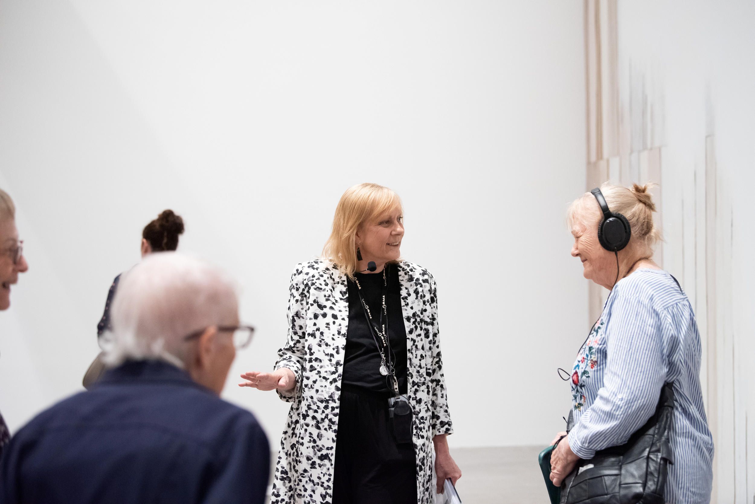 Visitor using assistive listening device on a tour at GOMA | Photograph: M Sherwood