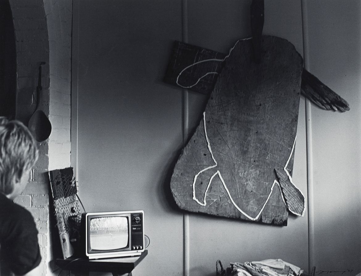 Glen O’Malley, Australia b.1948 / 14 January 1987, Atherton – Tom Risley had hung a sculpture on his wall. His son Jeff watched test cricket on T.V. (from ‘Journeys north’ portfolio) 1987 / Gelatin silver photograph on paper / 50.5 x 60.5cm / Purchased 1987 with the financial assistance of the Australian Bicentennial Authority to commemorate Australia’s Bicentenary in 1988 / Collection: Queensland Art Gallery | Gallery of Modern Art / © Glen O’Malley