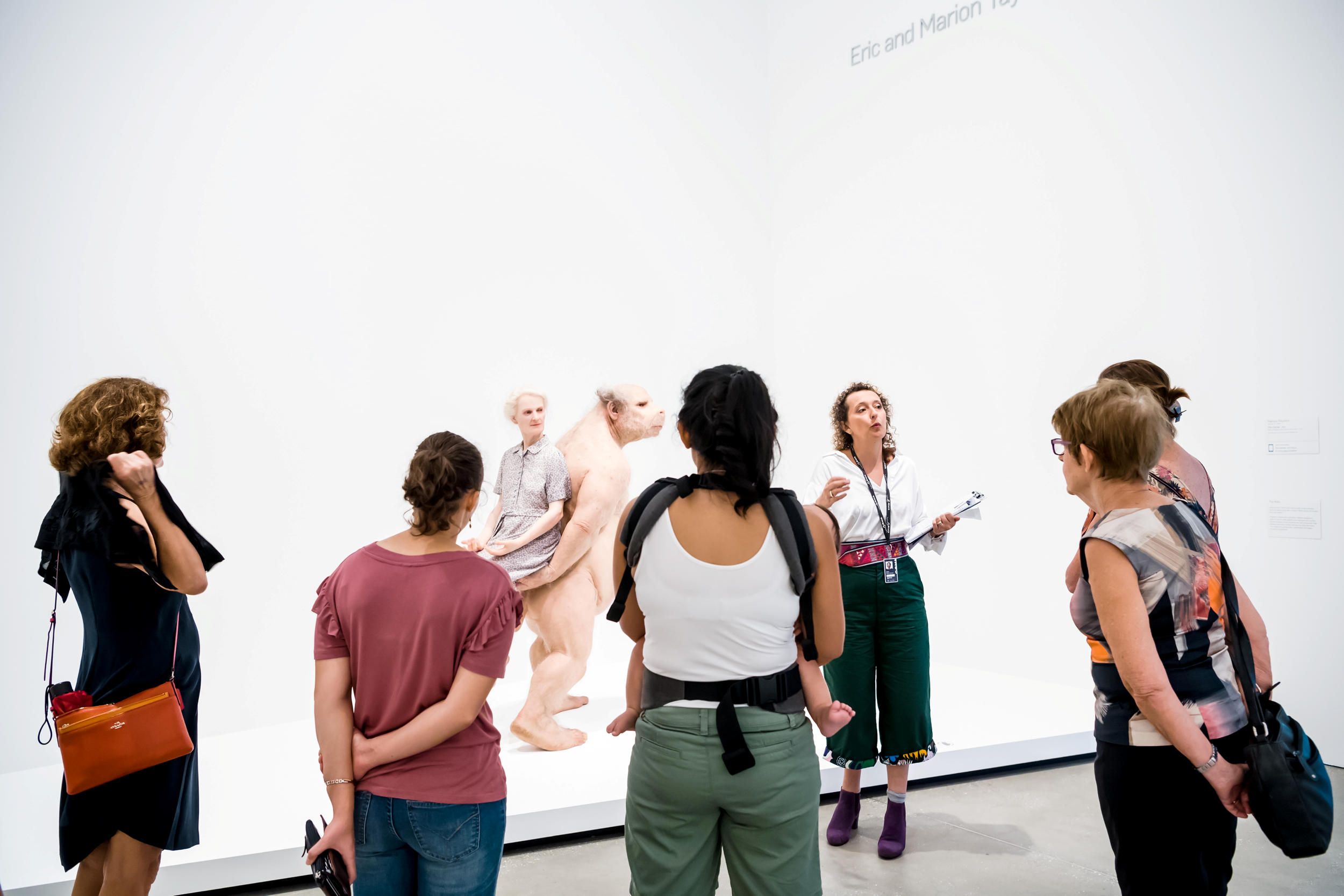 A Volunteer Guide engages visitors on a tour at the Gallery of Modern Art. Photography by Chloë Callistemon | QAGOMA

