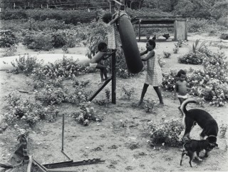 Glen O’Malley, Australia b.1948 / 2 February 1987, Seisia – Suneema’s children played in their backyard at a small settlement near the tip of Cape York Peninsula (from ‘Journeys north’ portfolio) 1987 / Gelatin silver photograph on paper / 50.8 x 60.6cm / Purchased 1987 with the financial assistance of the Australian Bicentennial Authority to commemorate Australia’s Bicentenary in 1988 / Collection: Queensland Art Gallery | Gallery of Modern Art / © Glen O’Malley