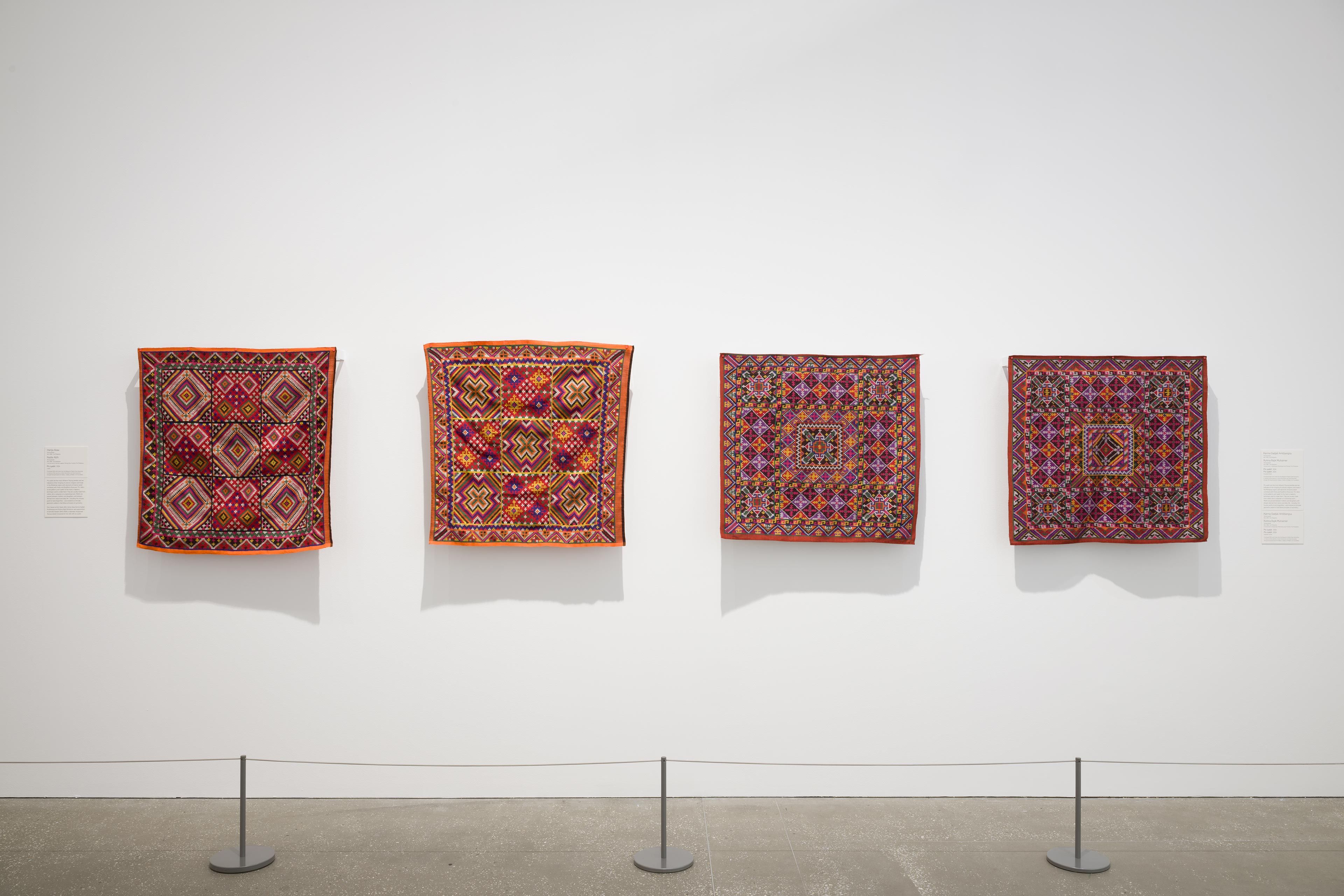 A view of collaboratively embroidered pis syabit textiles by Tausug artists (l–r): two works by Harija Alaw and Nadia Allih, and two by Karma Gadjali Amilbangsa and Ruhina Rajik Muhaimer, GOMA, November 2024 / Purchased 2024 with funds from the Bequest of Noela Clare Deutscher, in memory of her parents, A. Evans Deutscher and Clare Deutscher, through the Queensland Art Gallery | Gallery of Modern Art Foundation / © The artists / Photograph: C Callistemon, QAGOMA