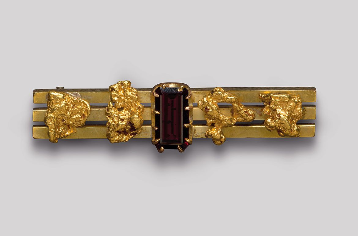 Goldfields bar brooch (three bars with / four nuggets and garnet) c.1880–1915 / Gold, gold nuggets and garnet / 1.5 x 5.3 x 1.5cm
Acc. 2011.101