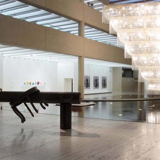 Ai Weiwei, China b.1957 / (foreground) Pillar through round table 2004-05 / Pair of elmwood half tables assembled into a single table (Qing dynasty 1644- 1911), bisected horizontally by an ironwood pillar (Qing dynasty 1644-1911), on two ironwood pillar fragments / 140 x 656.5 x 123cm (installed) / Purchased 2006. The Queensland Government’s Gallery of Modern Art Acquisitions Fund / Boomerang 2006 / Glass lustres, plated steel, electric cables, LED lamps / 700 x 860 x 290cm / Gift of the artist through the Queensland Art Gallery Foundation 2007 / Collection: Queensland Art Gallery | Gallery of Modern Art / © Ai Weiwei / Photograph: N. Harth © QAGOMA