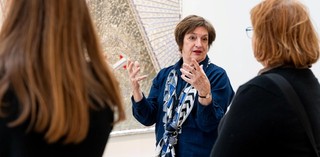 A Volunteer Guide engages visitors on a tour at the Gallery Of Modern Art. Photography by Chloë Callistemon | QAGOMA