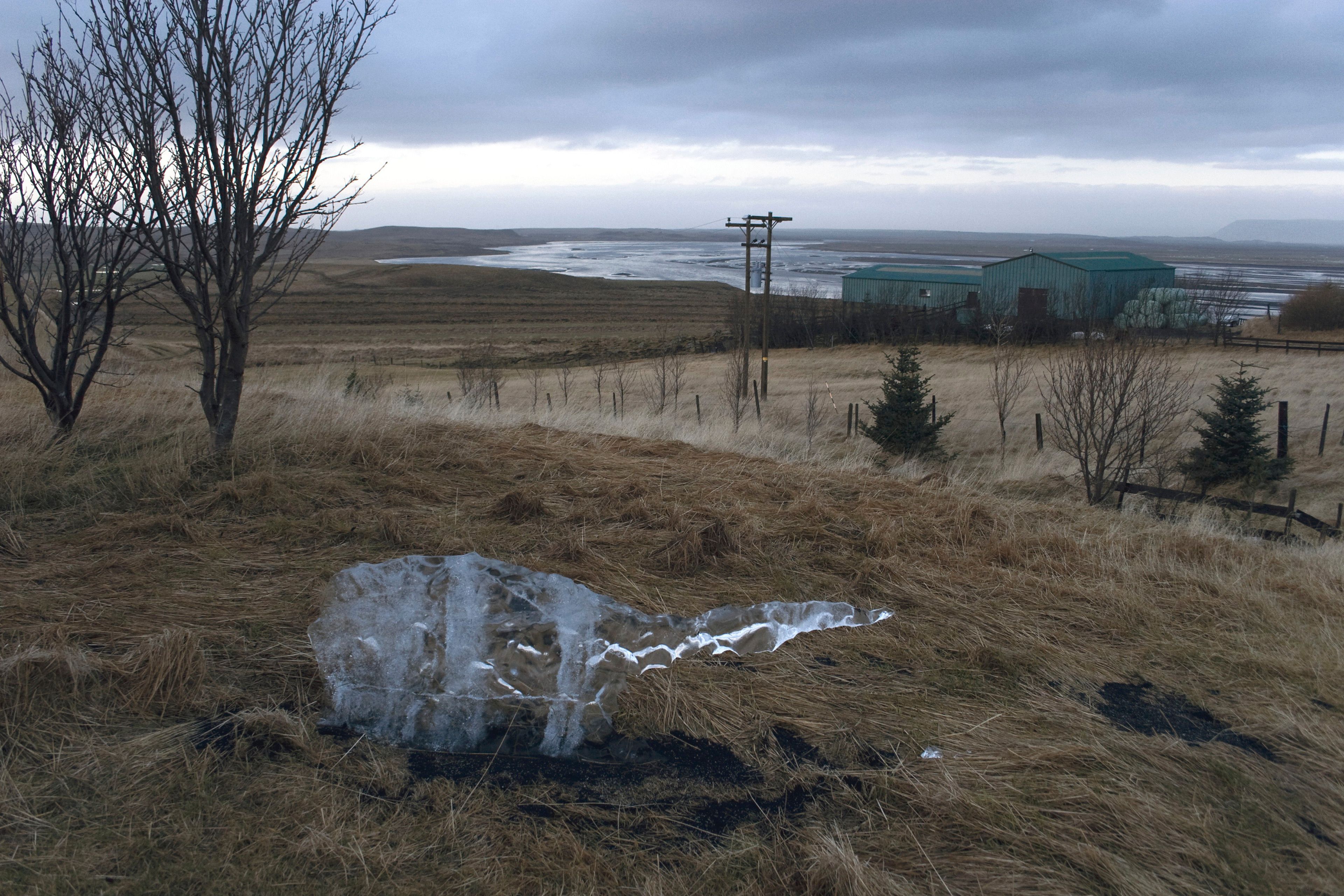 A detail view of a photograph documenting the gradual melting of an ice block in an Icelandic landscape.
