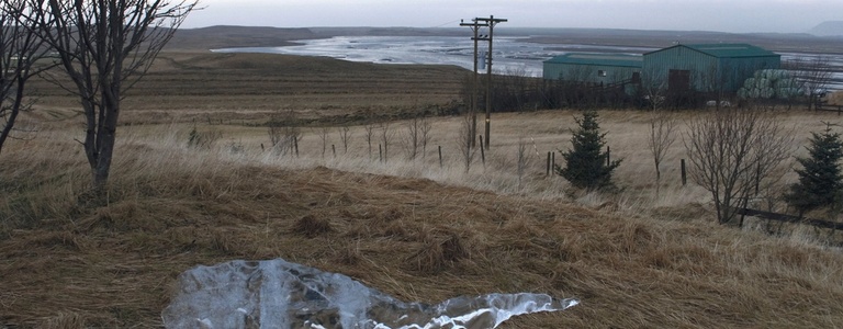 A detail view of a photograph documenting the gradual melting of an ice block in an Icelandic landscape.