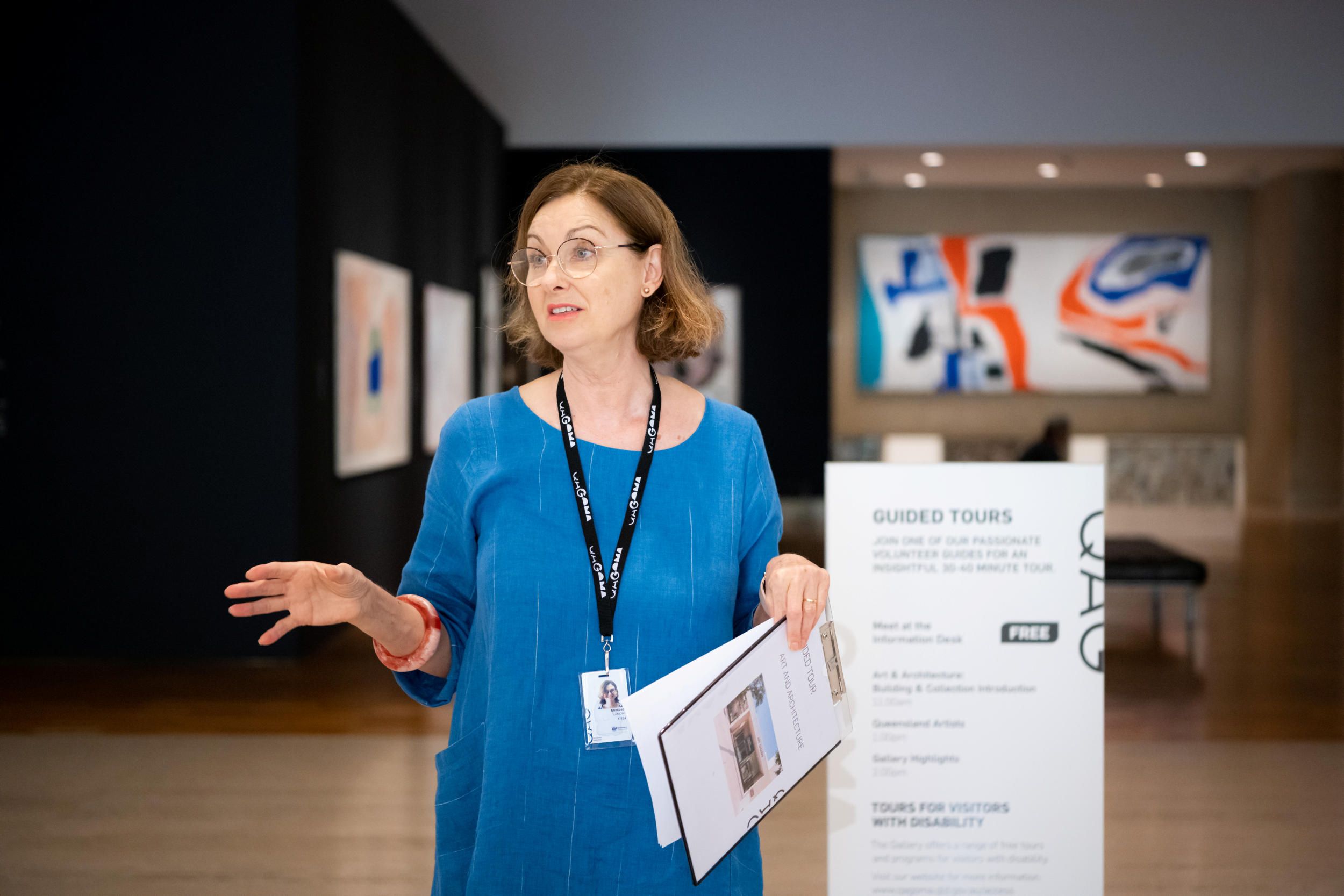 A Volunteer Guide engages visitors on a tour at the Queensland Art Gallery / Photograph: C. Callistemon / © QAGOMA