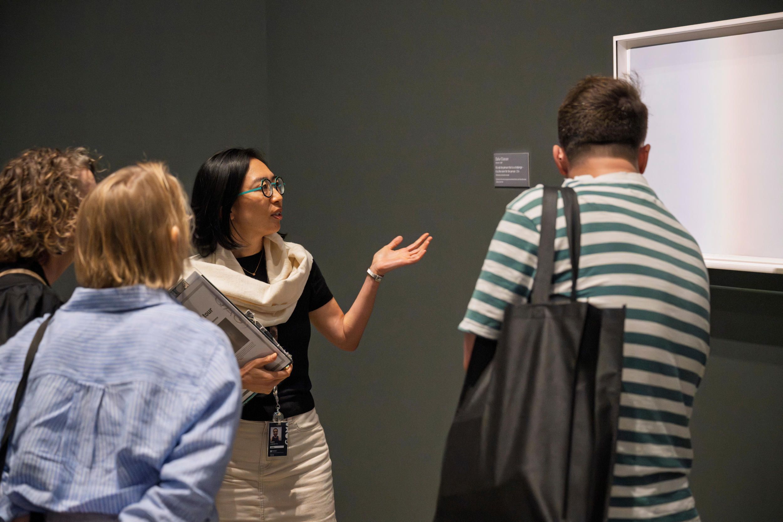 A Volunteer Guide engages visitors on a tour at the Gallery of Modern Art Gallery | Photograph: N. Umek | © QAGOMA