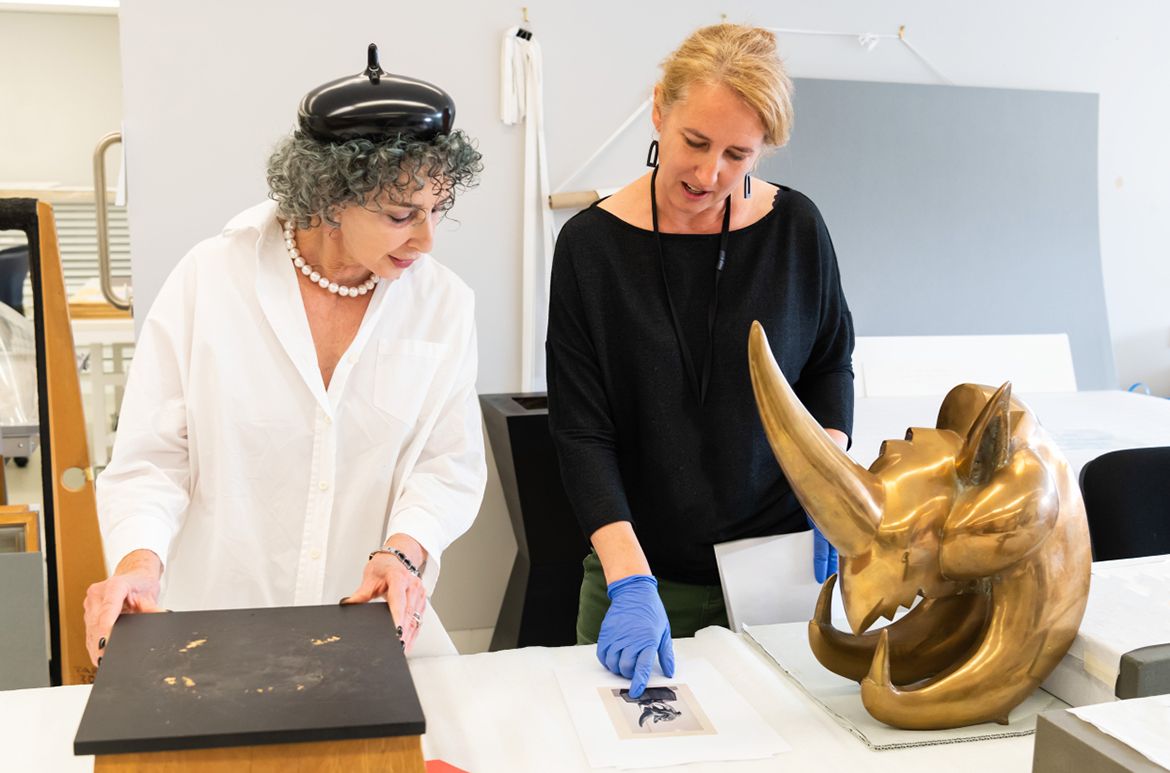 Gallerist Anna Schwartz (left) on her visit to QAGOMA Conservation, with Joel Elenberg’s Rhinoceros head, discussing the proposed treatment with former conservator Rhiannon Walker / Photograph: N Harth © QAGOMA