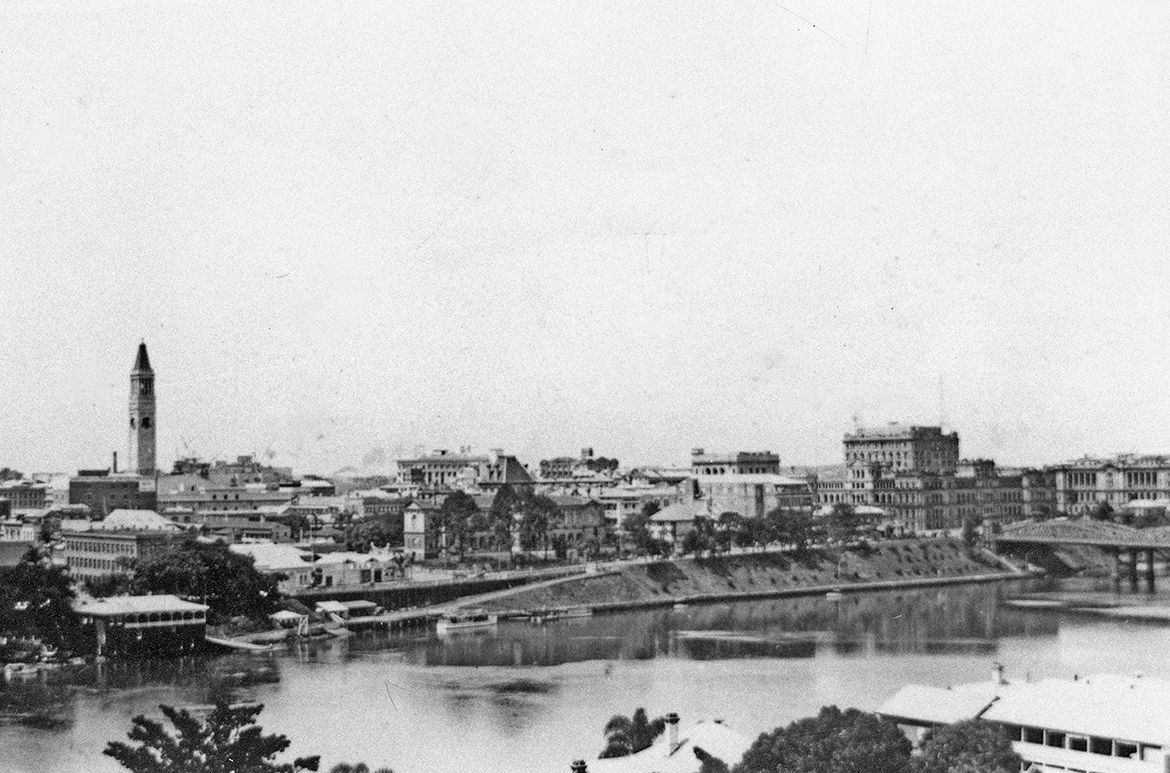 View of Brisbane across the South Brisbane Reach of the river to the City Hall’s clock tower with the O'Connor Boathouse & Commercial Rowing Club in the left foreground c.1930 / 99183507293002061 / Courtesy: John Oxley Library, State Library of Queensland, Brisbane