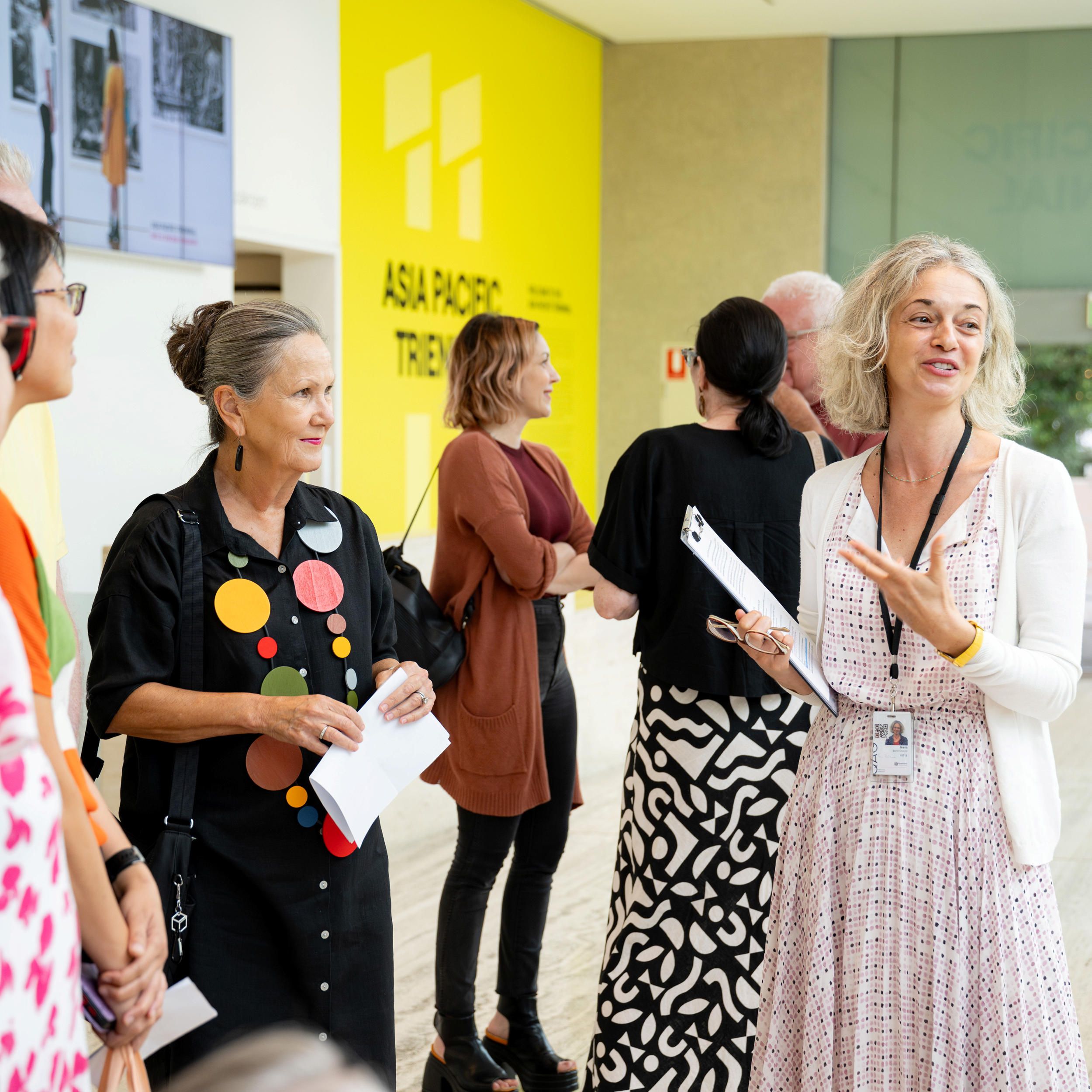 A Volunteer Guide engages visitors on a tour at the Queensland Art Gallery / Installation View / Photograph: C. Callistemon / © QAGOMA
