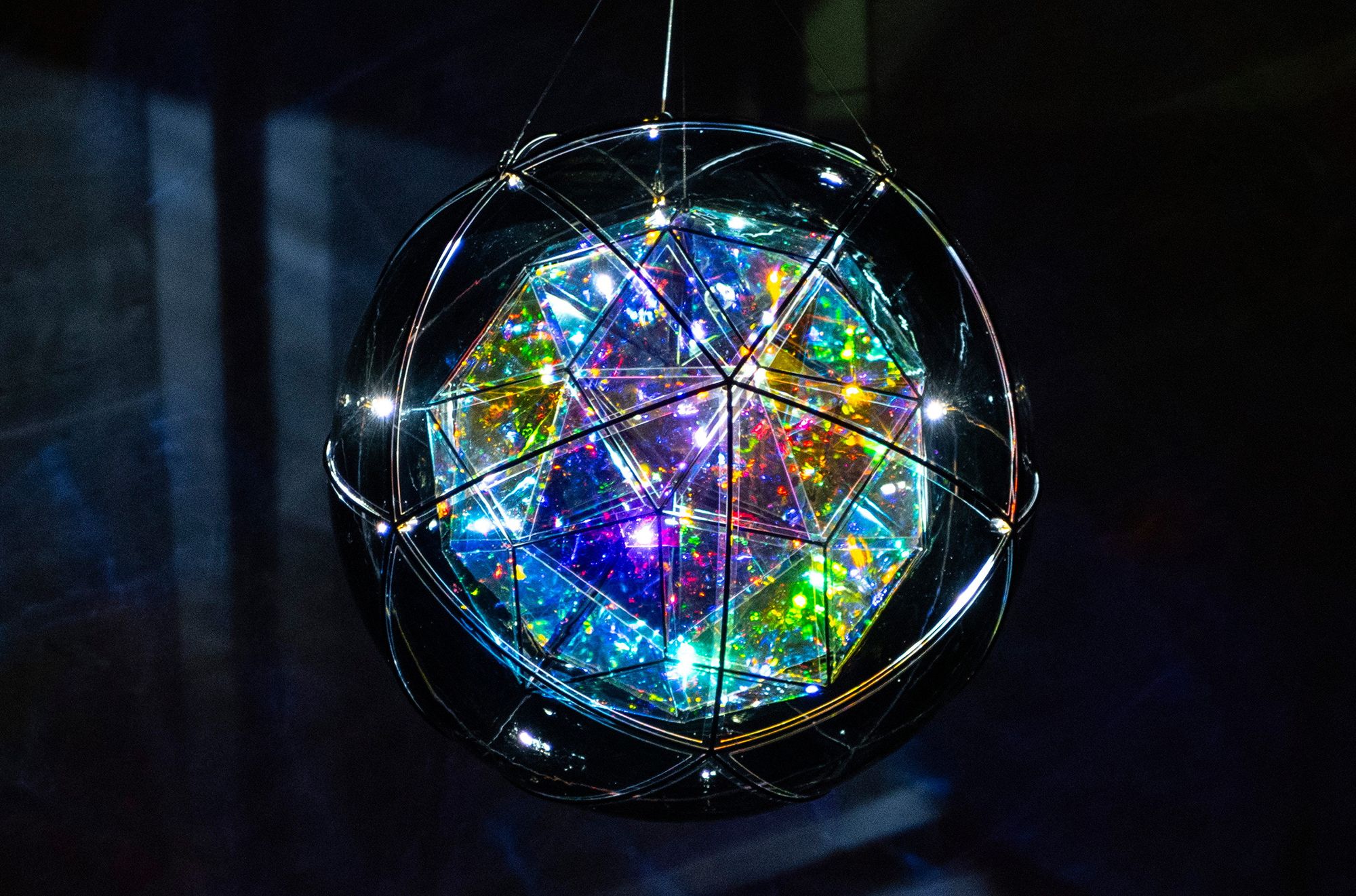 Olafur Eliasson, Denmark b.1967 / Firefly city 2025 / Coloured glass (purple), coloured glass (clear) with semi-transparent mirror colour-effect filter, colour-effect filter glass (blue, red), LEDs, aluminium, stainless steel, paint (black), wire, motor, ballast / 103cm (diam.) / © Olafur Eliasson / Courtesy: The artist; neugerriemschneider, Berlin; and Tanya Bonakdar Gallery, New York / Photograph: N Umek © QAGOMA