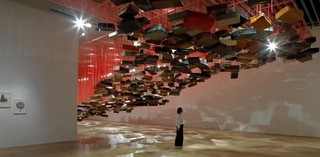 Chiharu Shiota, Japan b.1972 / Accumulation - Searching for the Destination 2014/2019 / Suitcase, motor and red rope / Dimensions variable / Courtesy: Galerie Templon, Paris/Brussels / Installation view: Shiota Chiharu: The Soul Trembles, Mori Art Museum, Tokyo, 2019 / Photo: Kioku Keizo / Photo courtesy: Mori Art Museum, Tokyo