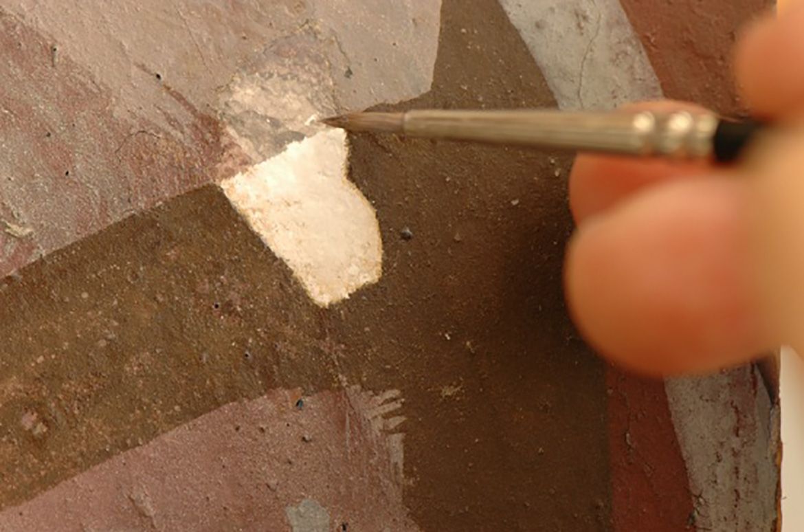 During the overpaint removal, the first image in this series shows the dark brown overpaint, the second the overpaint removed and the third the paper pulp fill and the beginning of inpainting using watercolour. The last image shows the loss after treatment.