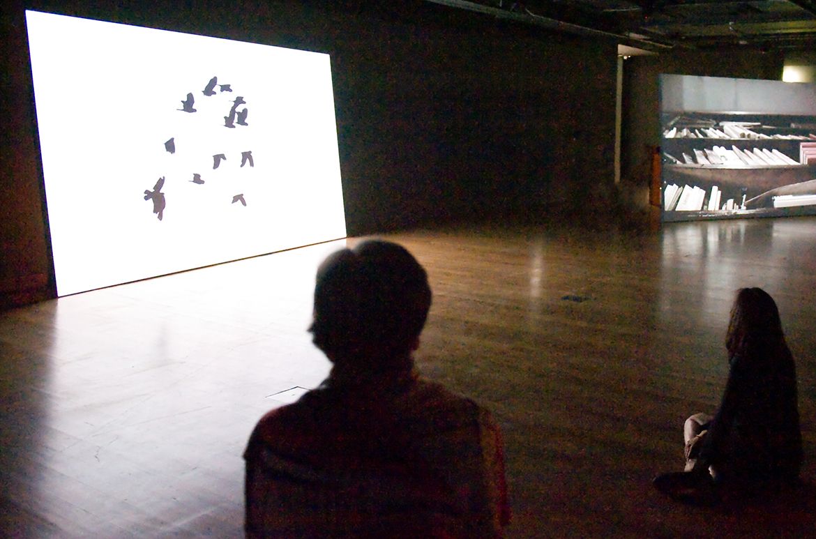 Hiraki Sawa, Japan b.1977 / Installation view O 2009 / Multi-channel video installation: 3-channel video projection exhibited from hard drive, HD video, 16:9, colour and black and white, 5-channel sound, 8:00 minutes; 10 channel video installation exhibited on customised LCD monitors, HD video transferred to DVD, 16:9, black and white, silent, 00:60 seconds; 5- channel sound by Organ Octet (edited by Dale Berning) exhibited on customised spinning speakers; customised metal light frames and light-bulb fixtures / Purchased 2010. Queensland Art Gallery Foundation / Collection: Queensland Art Gallery | Gallery of Modern Art / © Hiraki Sawa / Photographs: N Harth © QAGOMA