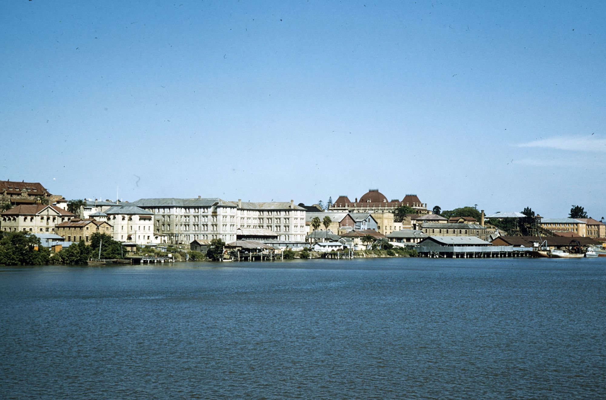 Buildings and wharves along William Street viewed from Victoria Bridge, 1958 / 99184072916802061 / Courtesy: John Oxley Library, State Library of Queensland, Brisbane