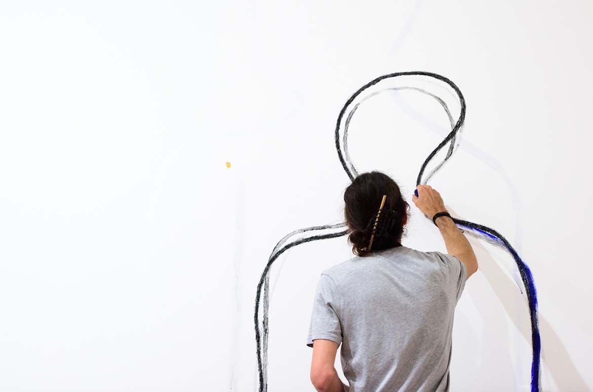 D Harding working on their commission Wall Composition in Reckitt’s Blue 2017 / Reckitt’s Blue laundry powder, charcoal and Grevillea robusta resin, incision into wall / Commissioned 2017 with funds from anonymous donors through the QAGOMA Foundation / Collection: Queensland Art Gallery | Gallery of Modern Art / © D Harding / Photograph: C Callistemon © QAGOMA