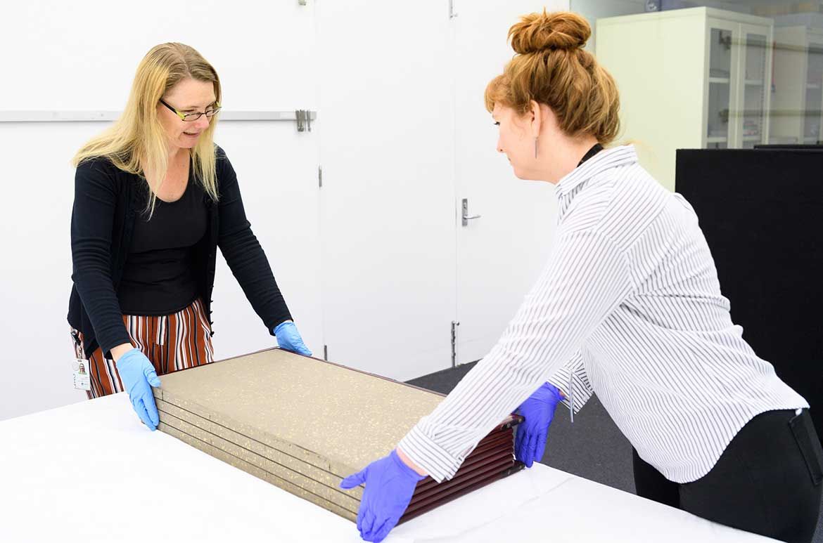 Kim Barrett and Emily Wakeling opening one of the screens in QAGOMA Collection Study Room / Photograph: C Callistemon © QAGOMA