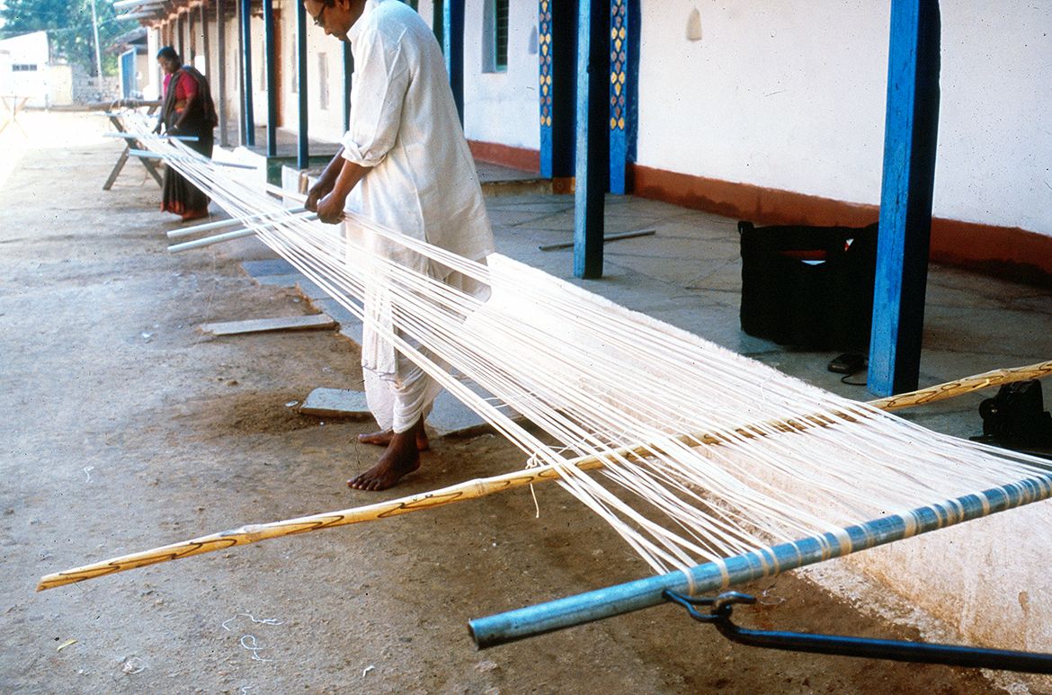 Craftsmen in Puttapaka stretch out warp yarn down the street, 1999 / Photograph: Dana McCown