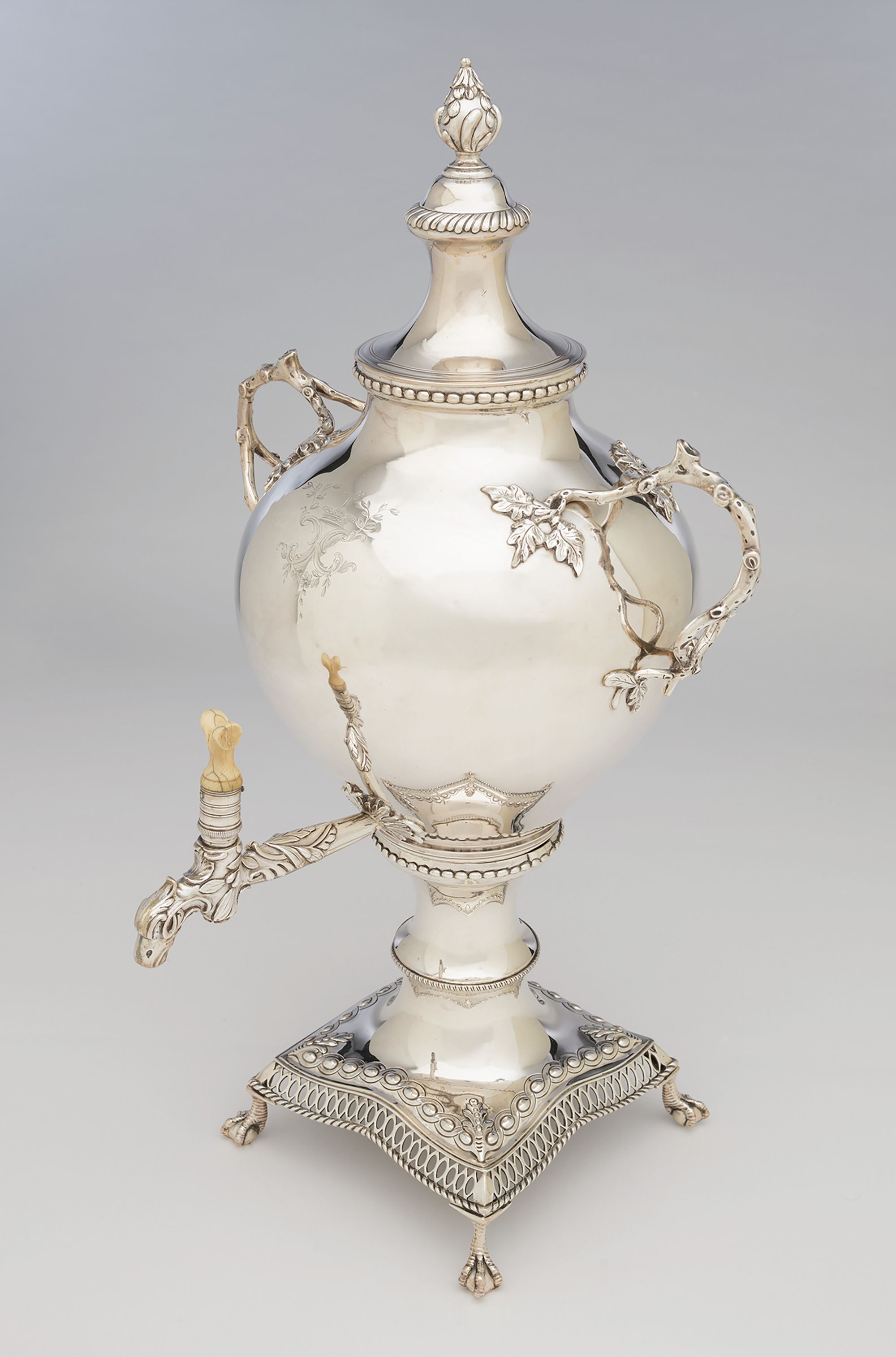 Attrib. To Charles Woodward, England / Tea urn c.1770-71 / Silver, the swelling body decorated in a modified rococo style with branch handles and foliage. The stand with pierced edge and with cast bird feet. Engraved with heraldic crest / 53.5 x 27.5 x 28cm (complete) / Bequest of Colonel FG Le M Gostling 1942 / Collection: Queensland Art Gallery | Gallery of Modern Art