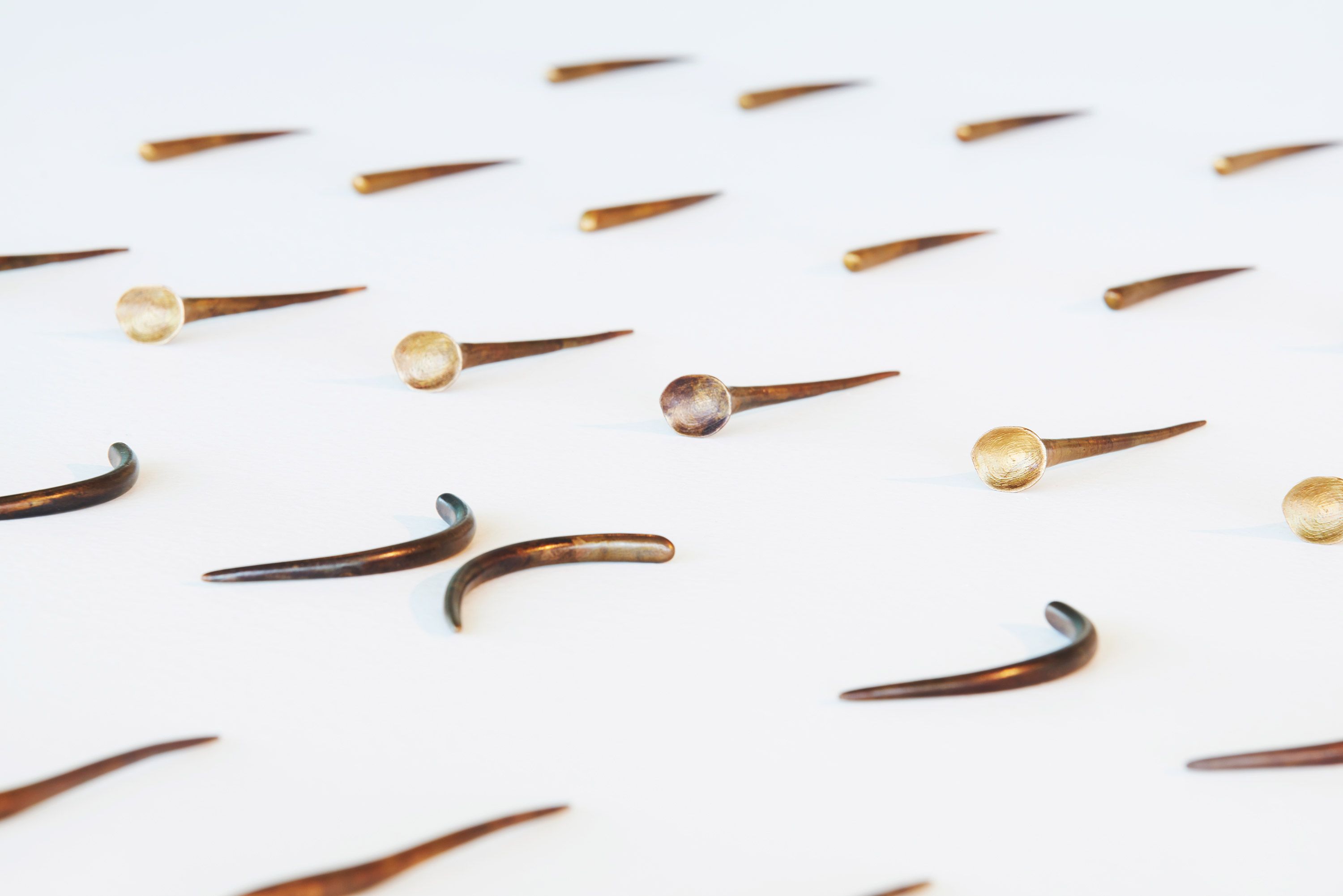 Judy Watson / Waanyi people / Australia b.1959 / resistance pins (detail) 2018 / Cast bronze with patina finish 42 pieces: 10 x 2 x 2cm ea. (approx.) / Courtesy the artist, Urban Art Projects and Milani Gallery, Brisbane (Meeanjin/Magandjin) / Image courtesy: Urban Art Projects / Photograph: Cian Sanders
