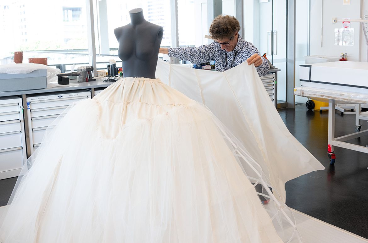 What is a fairy tale without a ball gown? Conservators Michael Marendy and Elizabeth Thompson are weaving their magic behind-the-scenes getting ready for ‘Fairy Tales’.

Conservator Michael Marendy preparing the support for the ‘Cream wedding dress’ designed by Eiko Ishioka for Mirror Mirror (2012) installed in ‘Fairy Tales’, Gallery of Modern Art (GOMA), Brisbane 2023 / Photograph: C Callistemon © QAGOMA