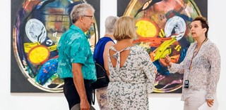 A Volunteer Guide engages visitors on a tour at the Queensland Art Gallery / Installation View / Photograph: J. Ruckli / © QAGOMA
