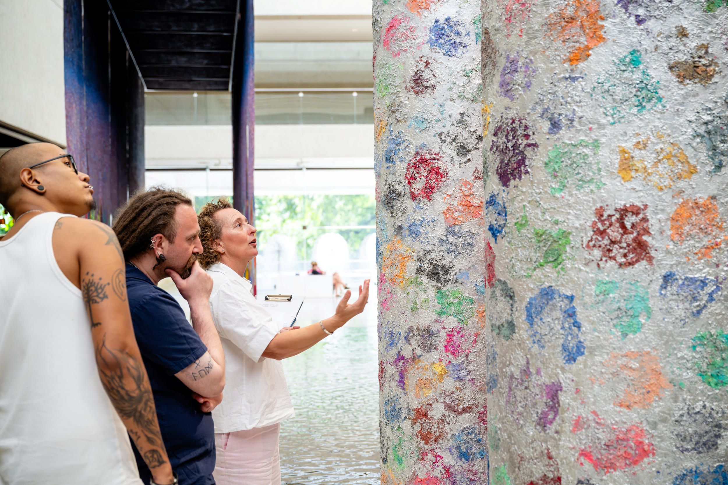 A Volunteer Guide engages visitors on a tour at the Queensland Art Gallery. Photograph: Photography by Joe Ruckli | QAGOMA