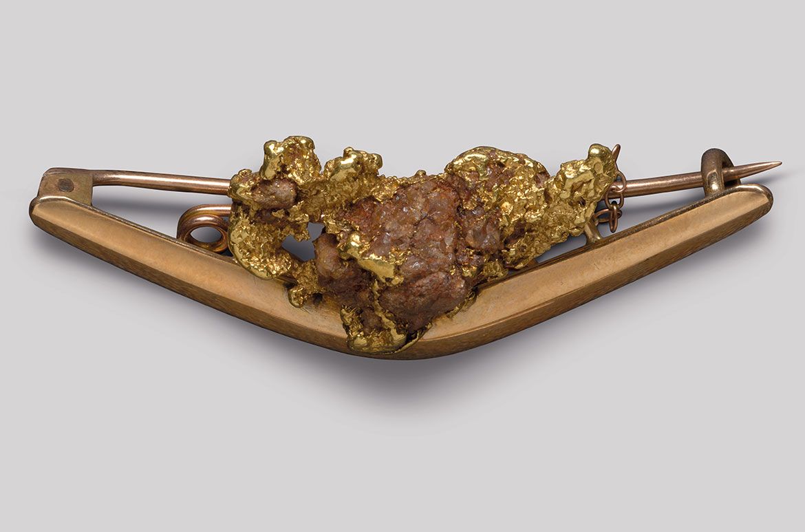 Goldfields brooch and chain (boomerang with gold nugget) c.1880–1915 / Gold and gold with red ore / 5.3 x 2.2. x 1.2cm
Acc. 2011.099