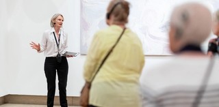 Visitors with hearing loss use assistive listening devices during a volunteer guided tour at the Queensland Art Gallery. Photograph: C. Callistemon