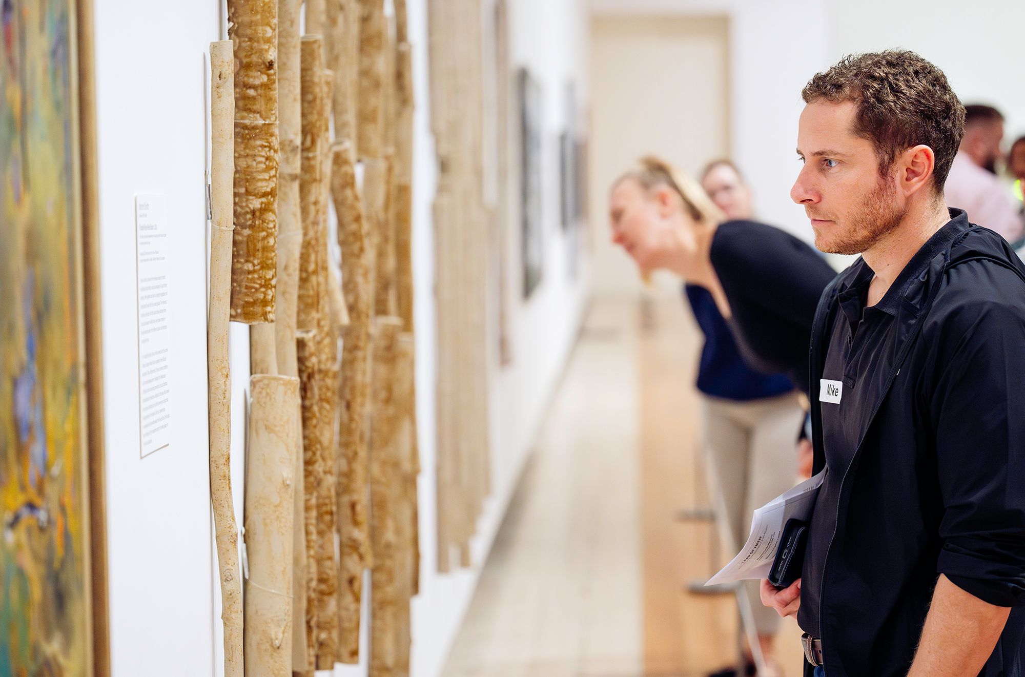 Veterans participating in a facilitated discussion of Yasmin Smith’s Flooded Rose Red Basin 2018 as part of the Art of Wellness program, QAG, July 2025 / Photograph: J Ruckli © QAGOMA