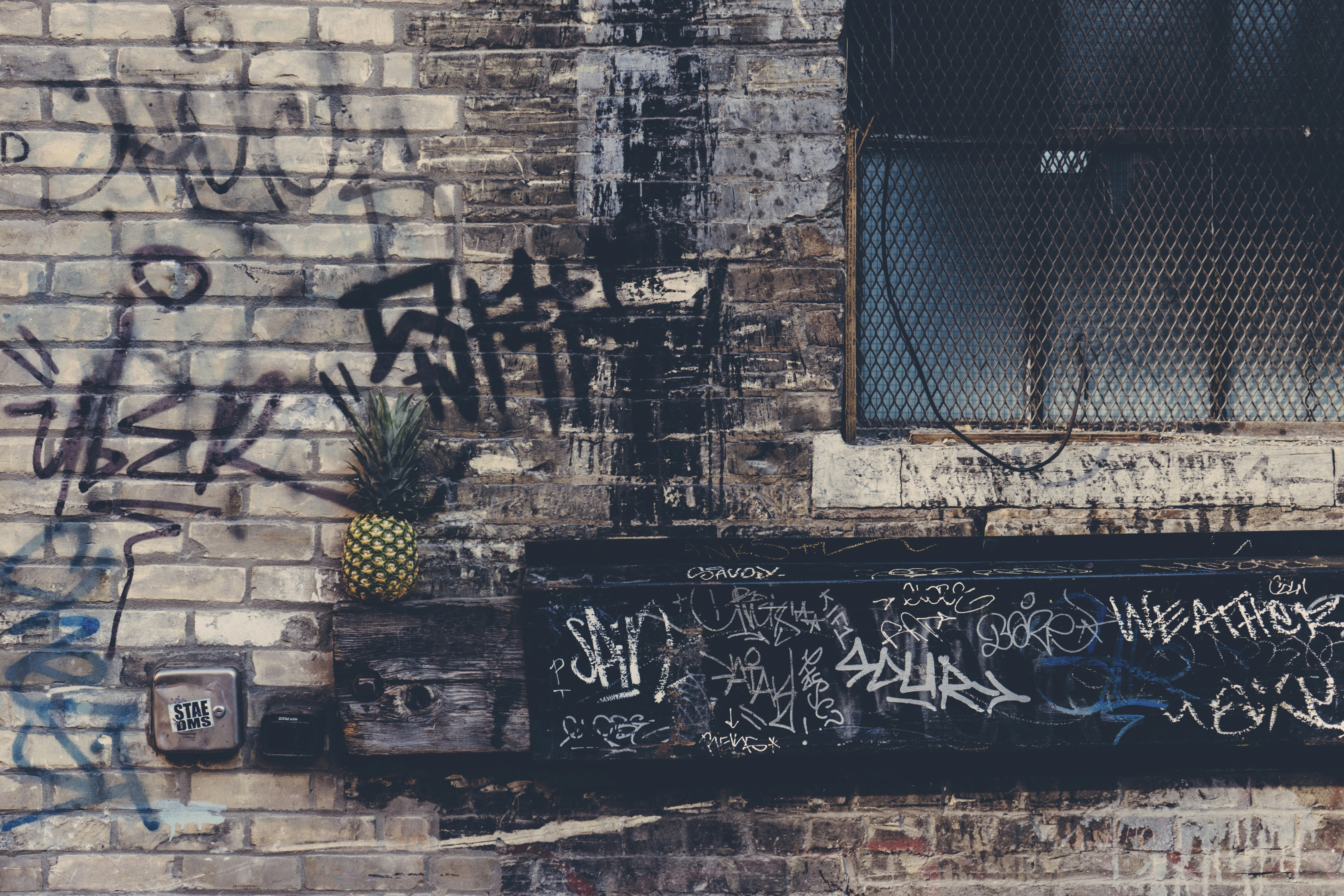 Image Spray paint graffiti on a brick wall and window ledge, an example of damage behind vandalism charges in Los Angeles