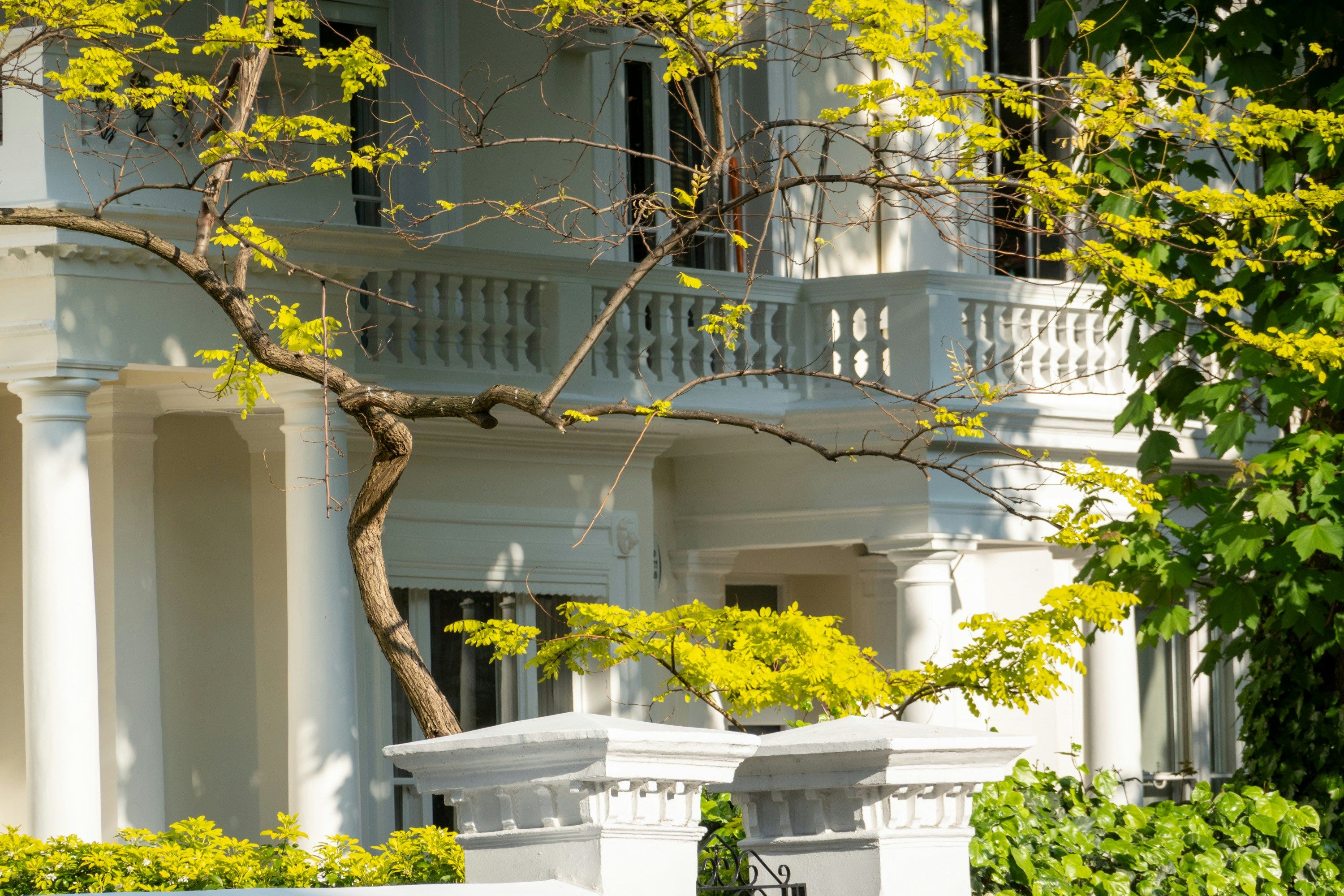 White columned Los Angeles residence behind a security fence, similar to homes protected by stalking restraining orders in California
