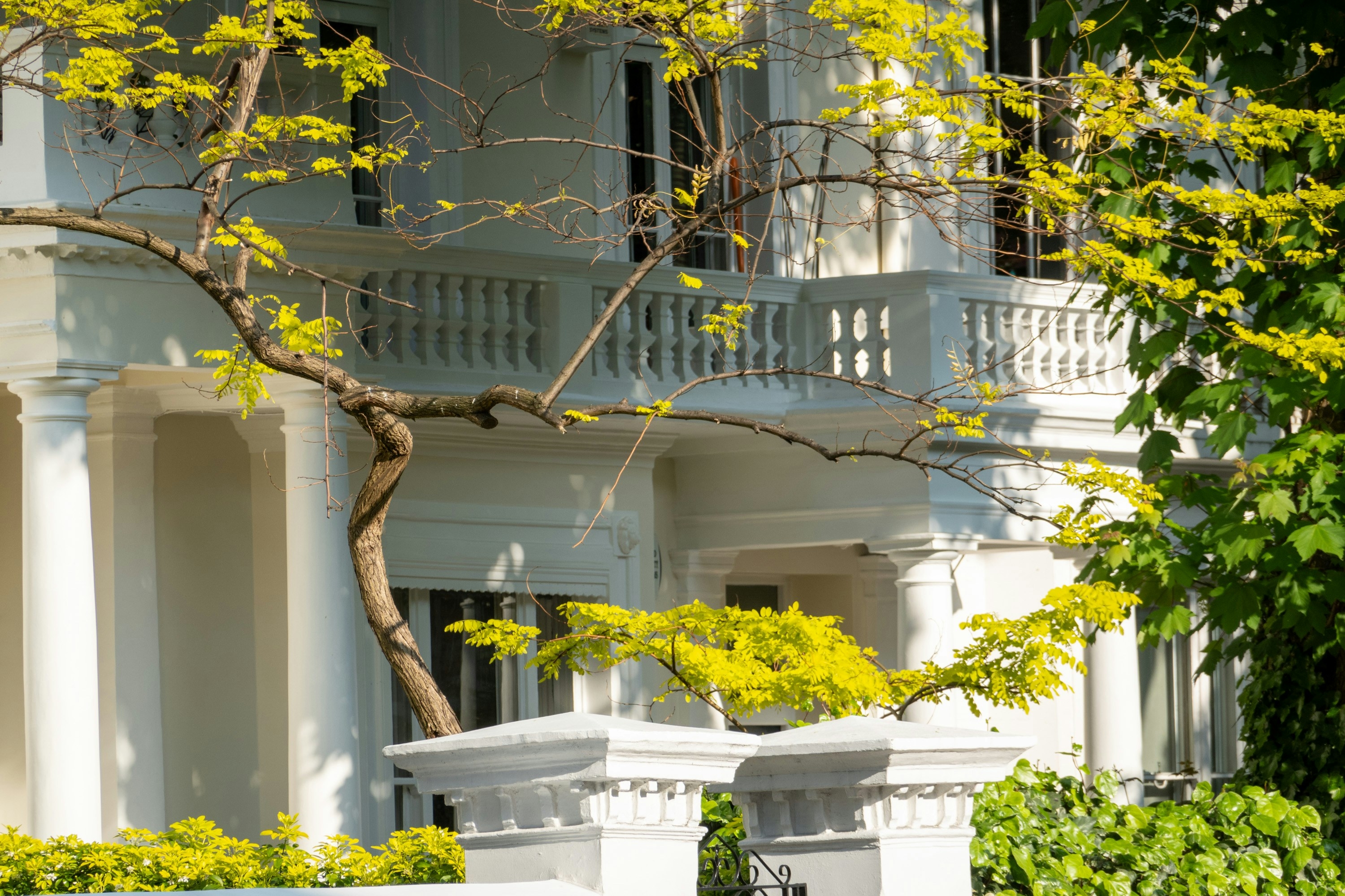 Image White columned Los Angeles residence behind a security fence, similar to homes protected by stalking restraining orders in California