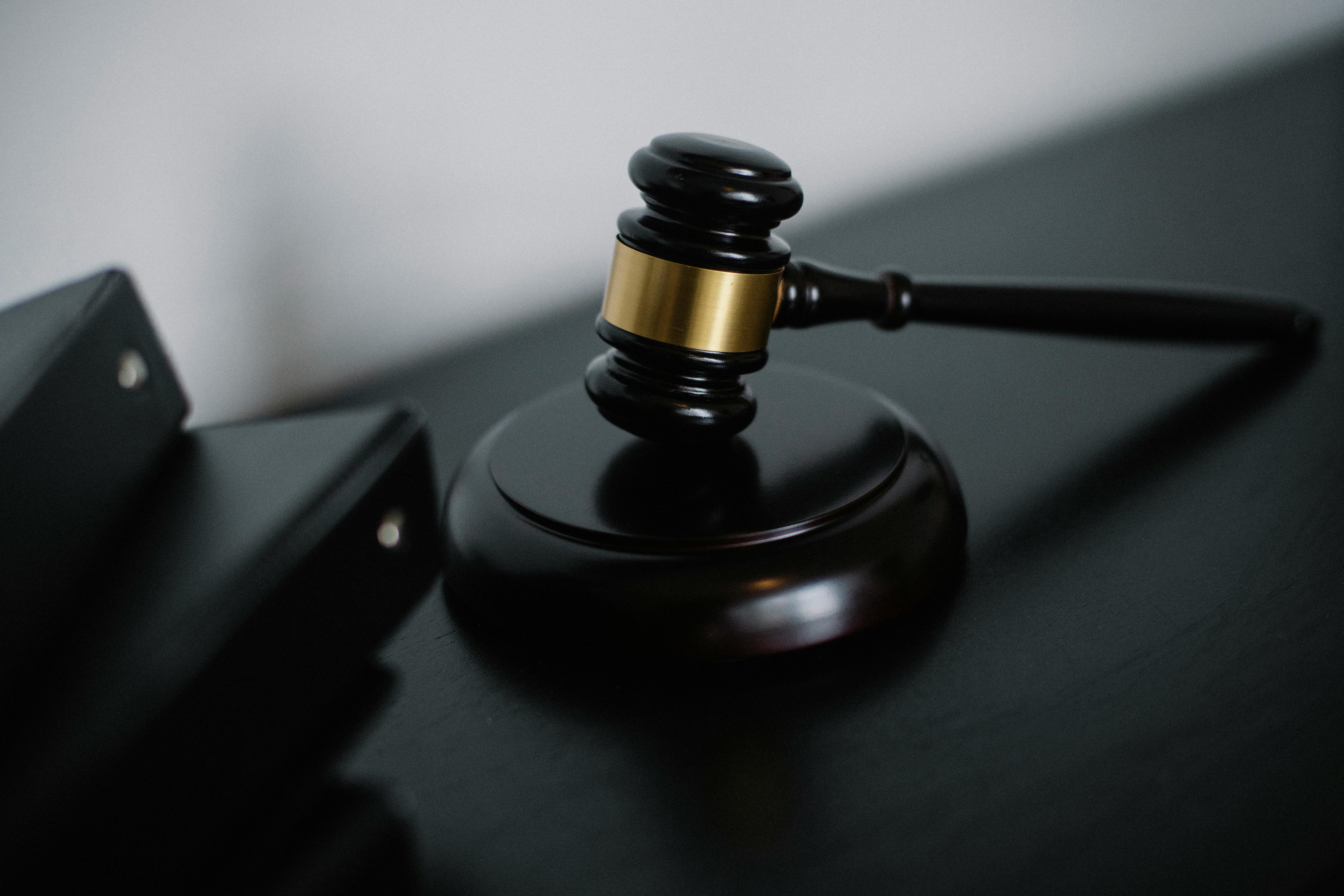 Judge’s gavel on a dark courtroom desk, representing what happens when a restraining order gets dropped in California.
