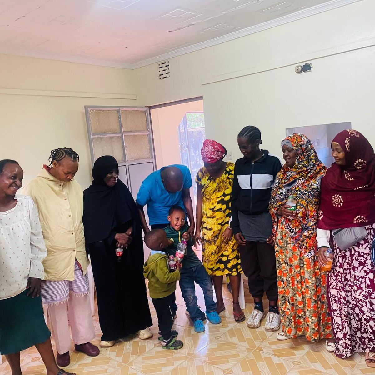Families moving together in a Kigali neighbourhood, reflecting the founder's relocation