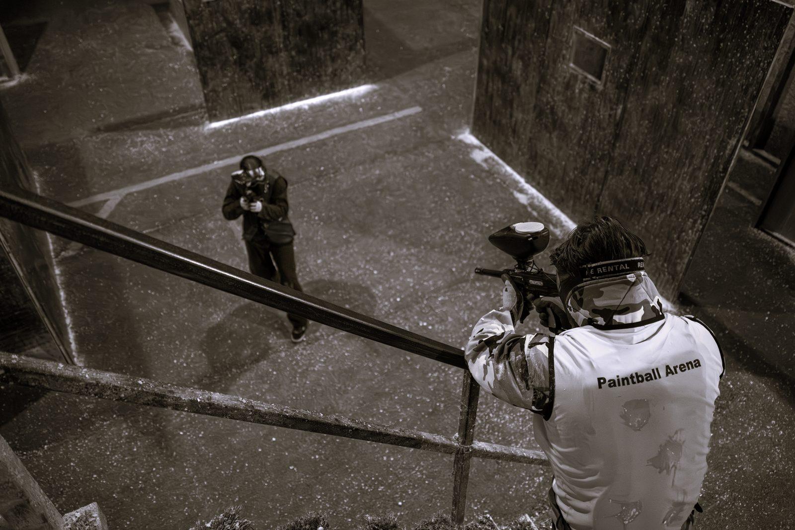 Un joueur vise depuis un escalier un adversaire en bas dans la salle
