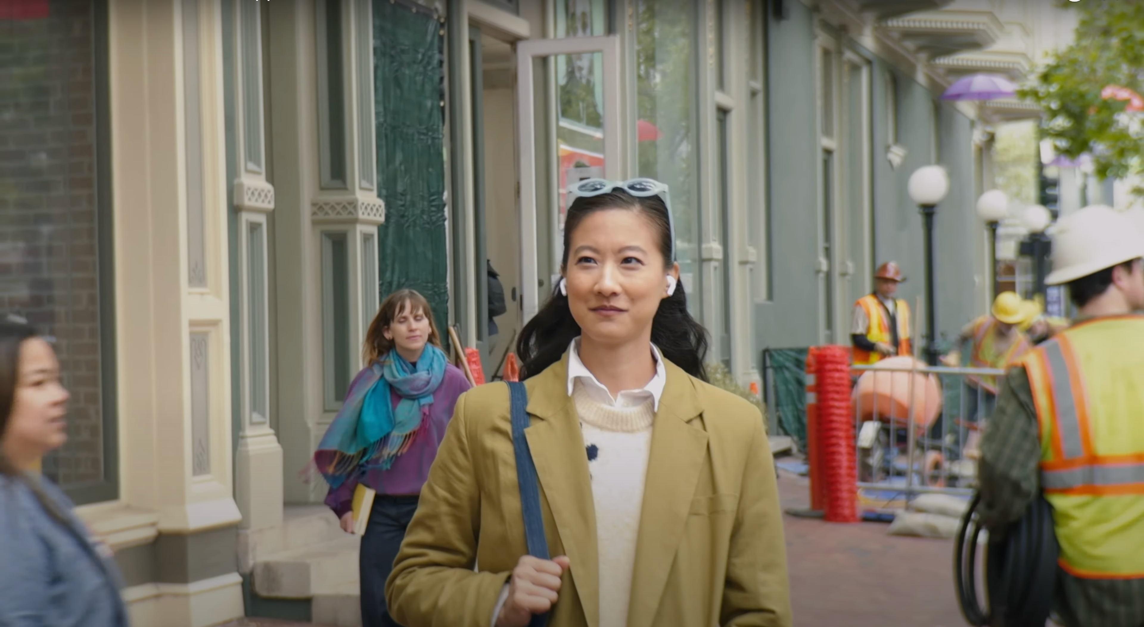 Photo of woman using AirPods in noisy environment to demonstrate Voice Isolation feature.