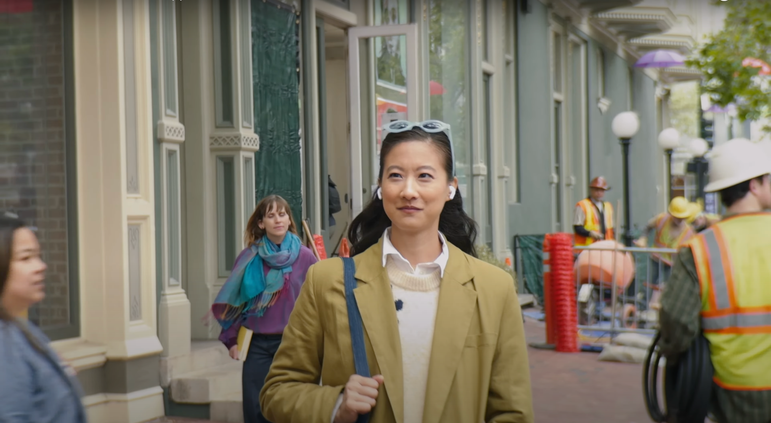 Photo of woman using AirPods in noisy environment to demonstrate Voice Isolation feature.