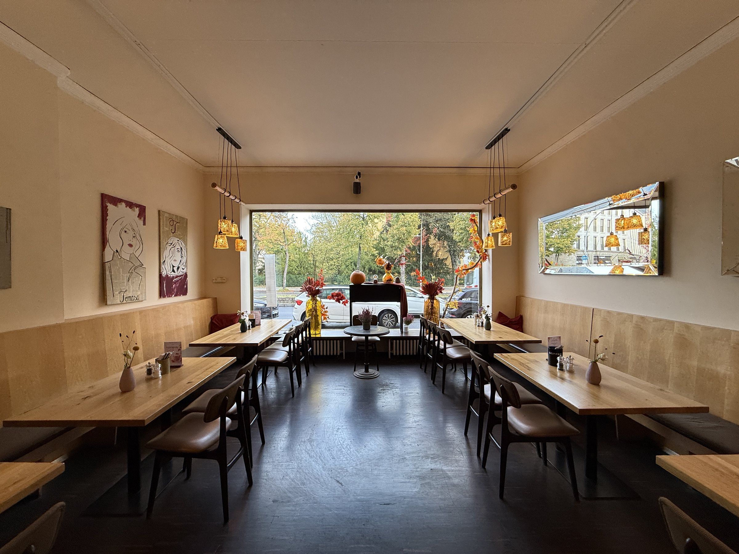 Das Asia Zimmer mit langen Holztischen und großem Fenster zur Straße