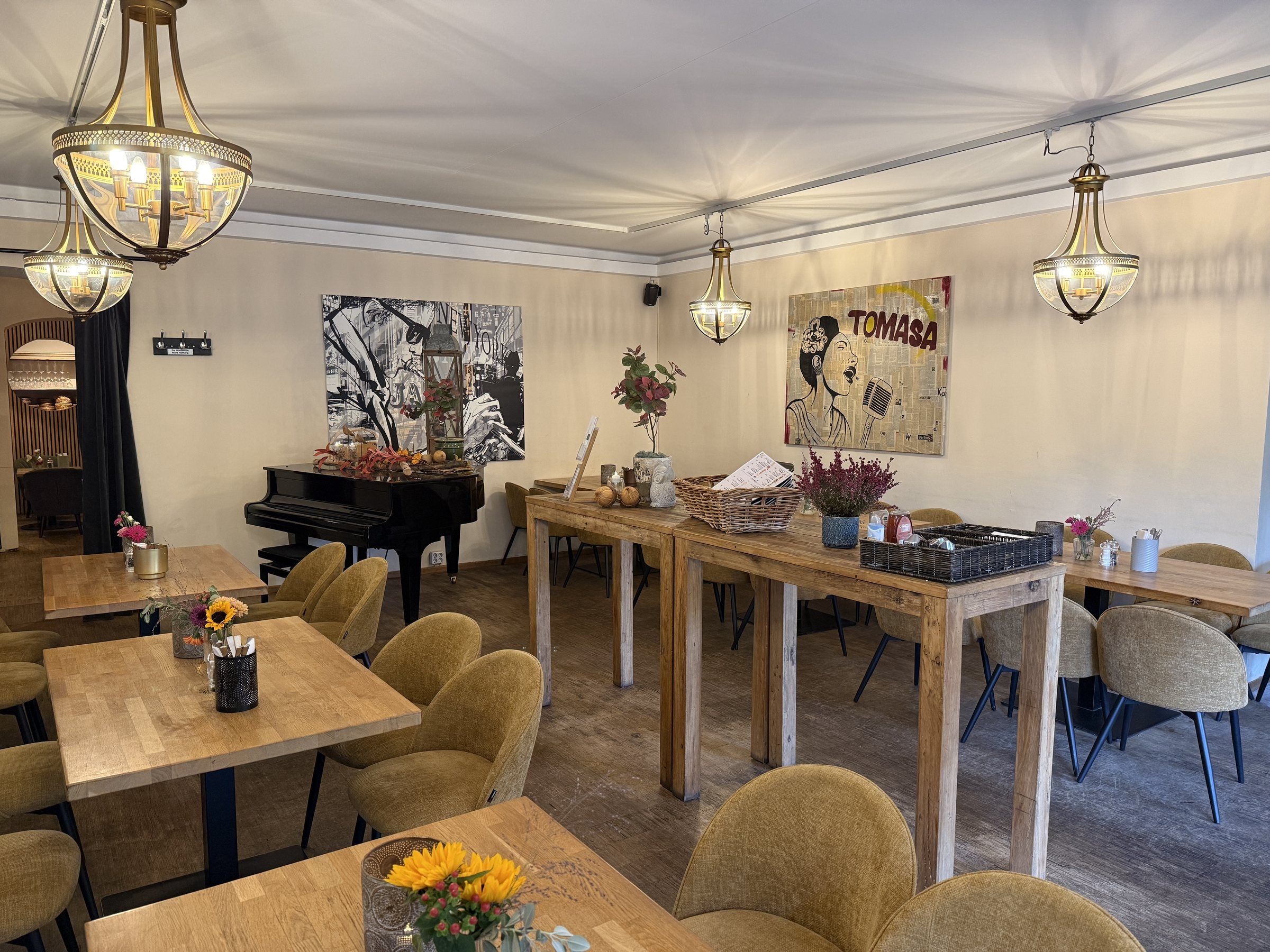 Piano Lounge mit Flügel, Kronleuchtern, Stehtischen und Sesseln in Senfgelb